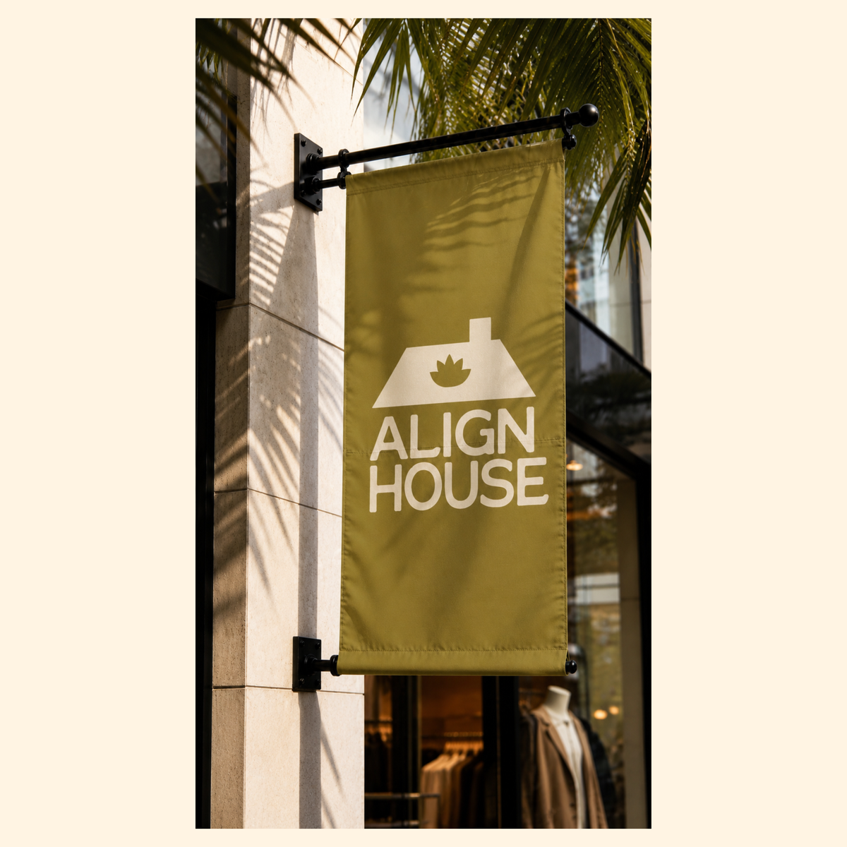 A vertical olive green banner flag mounted on a black metal bracket outside a building. The banner features a white graphic of a house with a maple leaf on top and the text 'ALIGN HOUSE' in white.